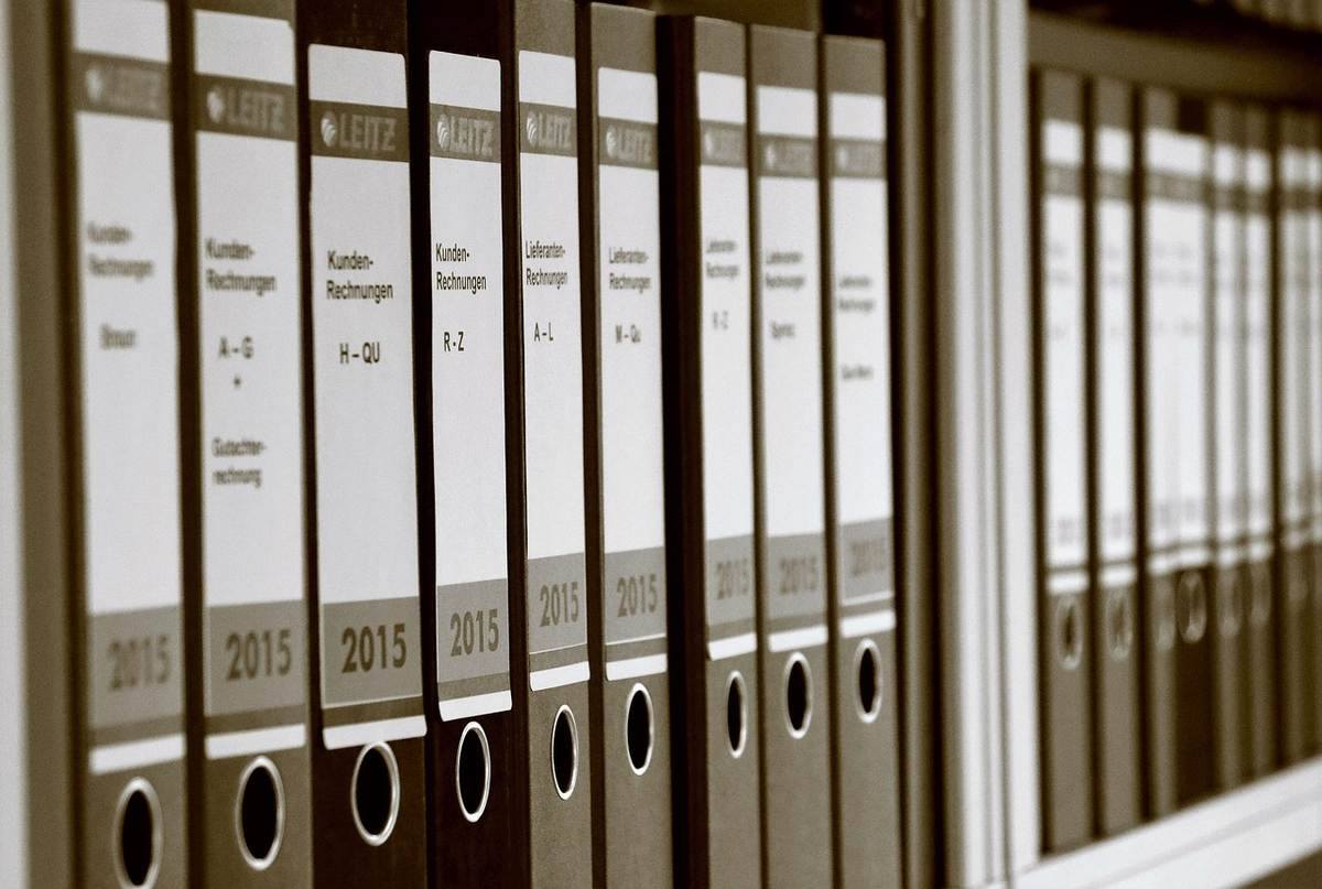 Dossiers archivés avec étiquettes et anneaux sur une étagère de bureau Dossiers archivés avec étiquettes et anneaux sur une étagère de bureau