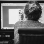 Une femme aux cheveux attachés travaille sur un ordinateur de bureau